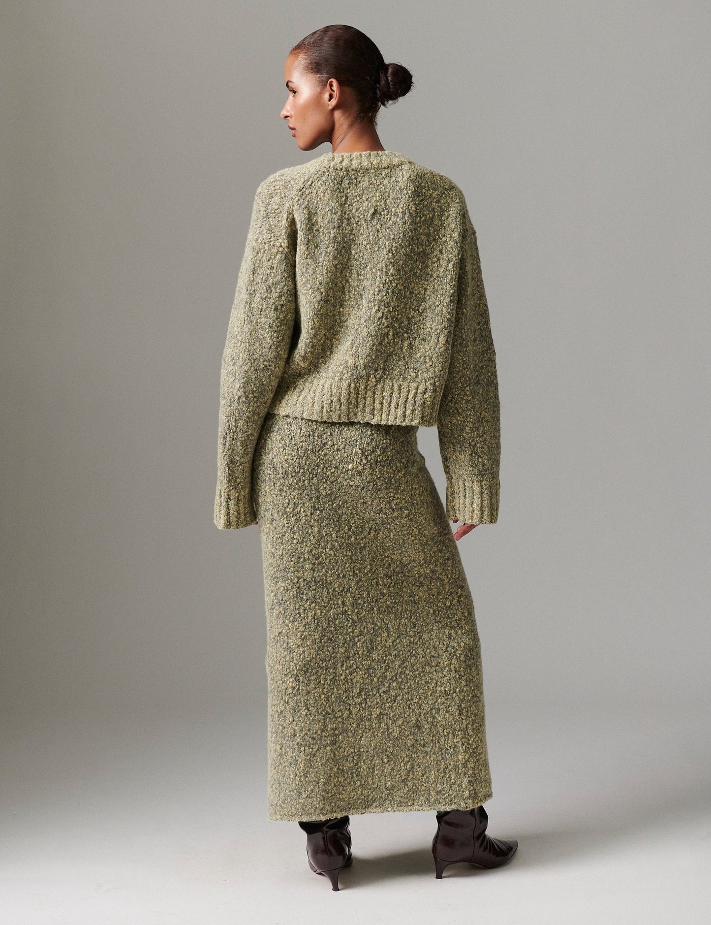 Model facing away wearing DAY Birger ét Mikkelsen Conor Winter Melange Cardigan in capers green with matching skirt, showing textured knit and relaxed fit.