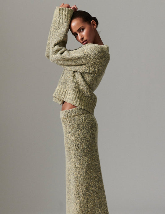 Side profile of model wearing DAY Birger ét Mikkelsen Conor Winter Melange Cardigan in capers green, paired with matching skirt.
