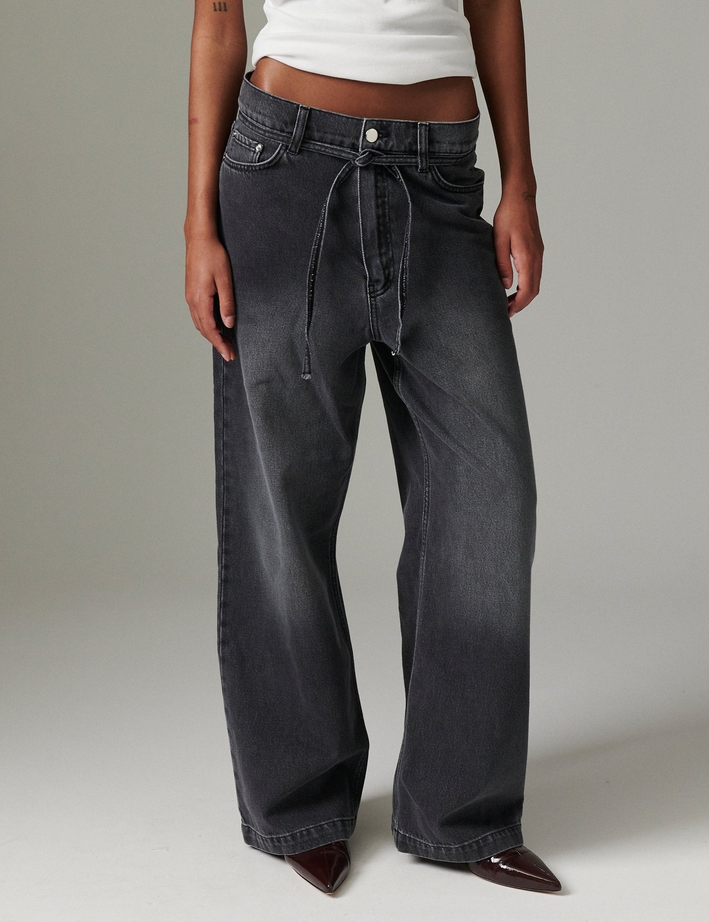 Close view of DAY Birger ét Mikkelsen Elijah Rigid Denim in washed black showing low-rise fit, straight-leg shape, and removable tie belt.
