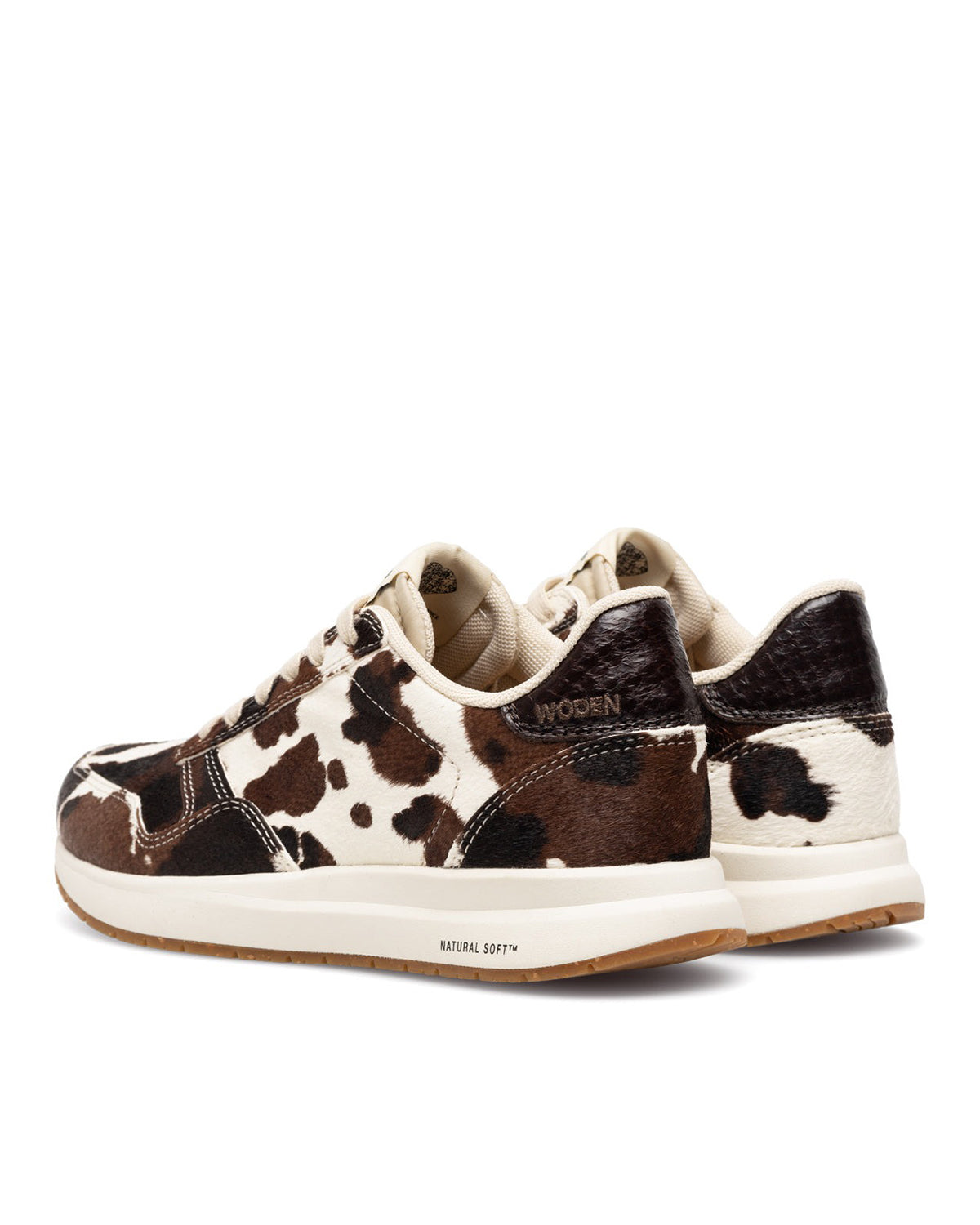 Brown and white cow print sneakers on a white background