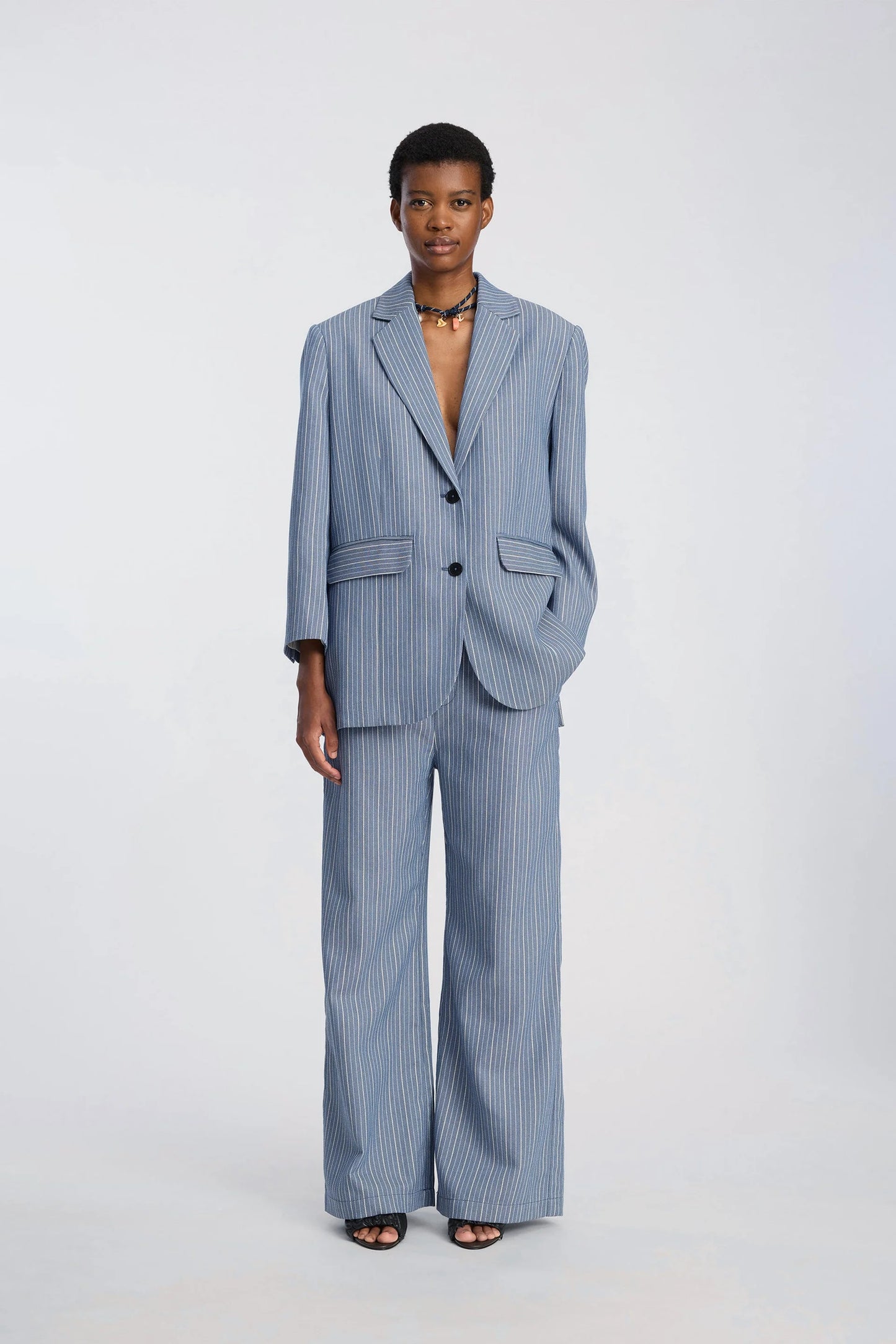 Person wearing a blue pinstripe suit on a white background
