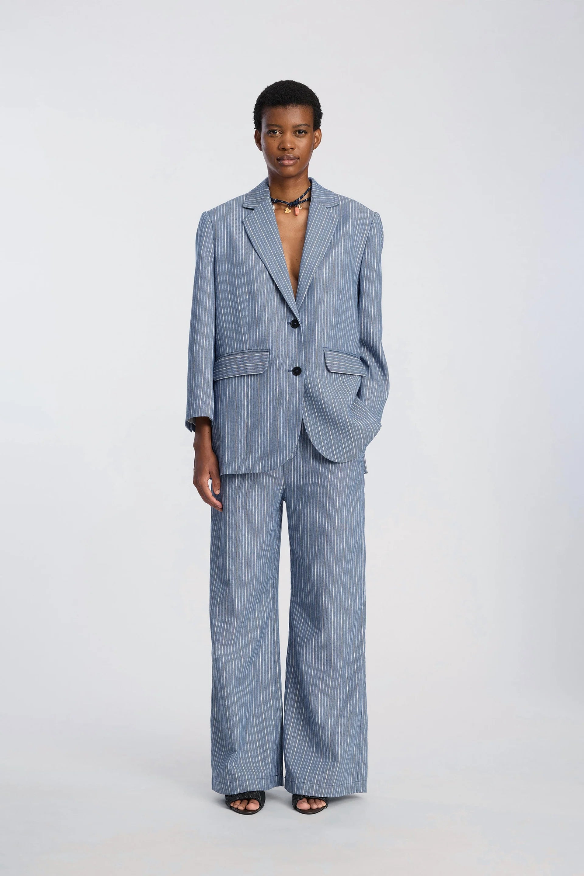 Person wearing a blue pinstripe suit on a white background