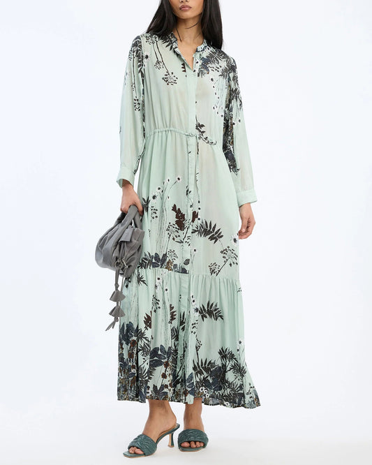 Woman wearing a floral dress holding a gray bag on a white background