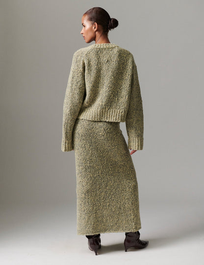 Model facing away wearing DAY Birger ét Mikkelsen Conor Winter Melange Cardigan in capers green with matching skirt, showing textured knit and relaxed fit.