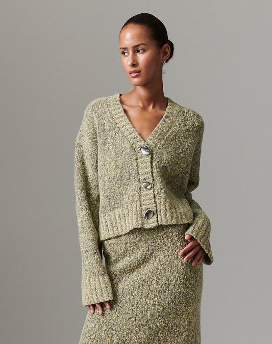 Close-up of model wearing DAY Birger ét Mikkelsen Conor Winter Melange Cardigan in capers green, showing oversized bauble buttons and textured knit.