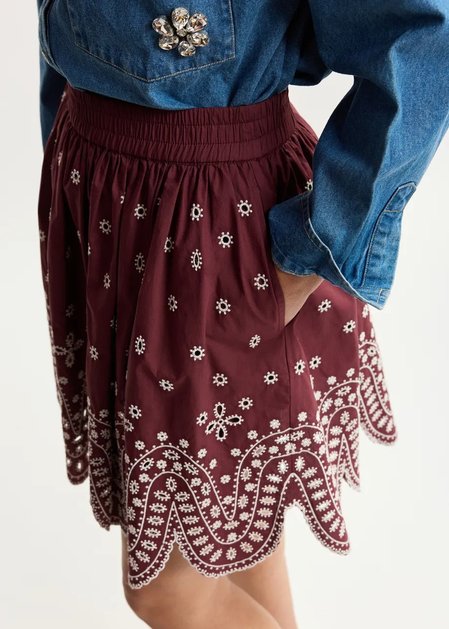 Dark red and white embroidered cotton skirt with scalloped hemline
