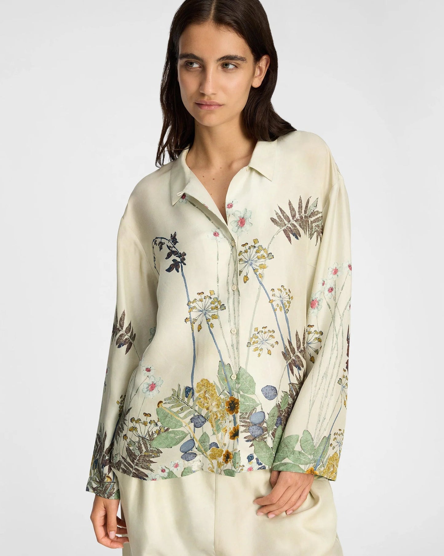 Woman wearing a floral blouse with a plain background
