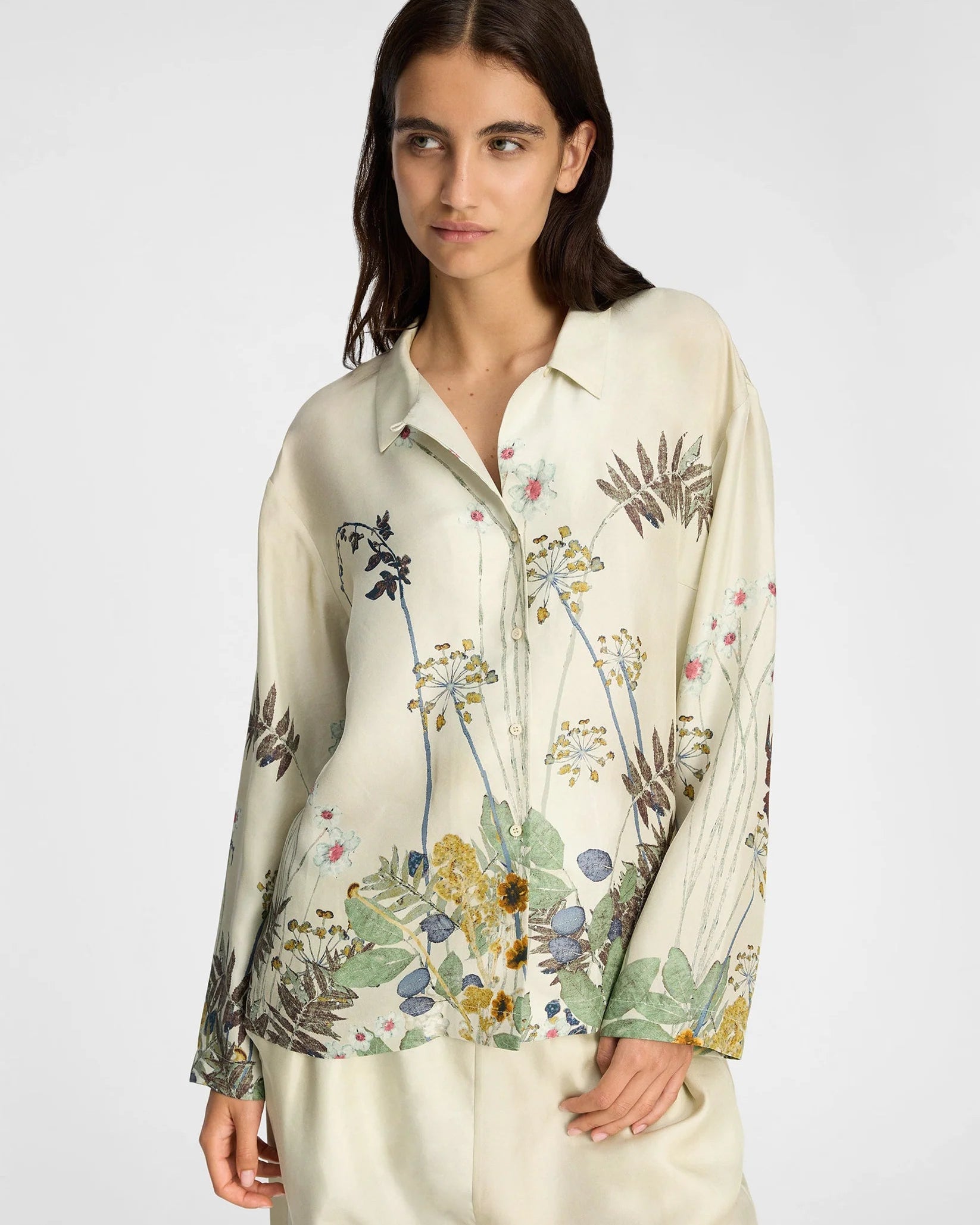 Woman wearing a floral blouse with a plain background