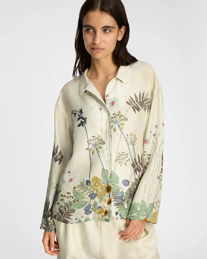 Woman wearing a floral blouse with a plain background