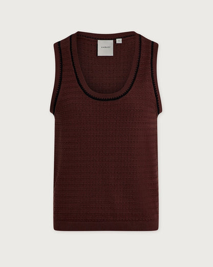A sleeveless ribbed knit tank top by Varley in deep burgundy, featuring a contrasting black ribbed trim along the scoop neckline, shown flat against a light gray background.