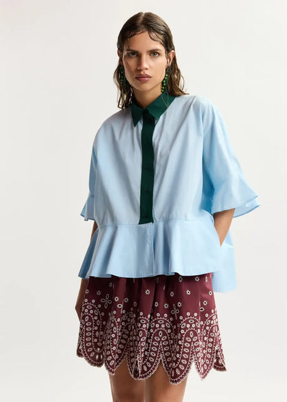 Light blue cotton peplum shirt with dark green contrast detailing
