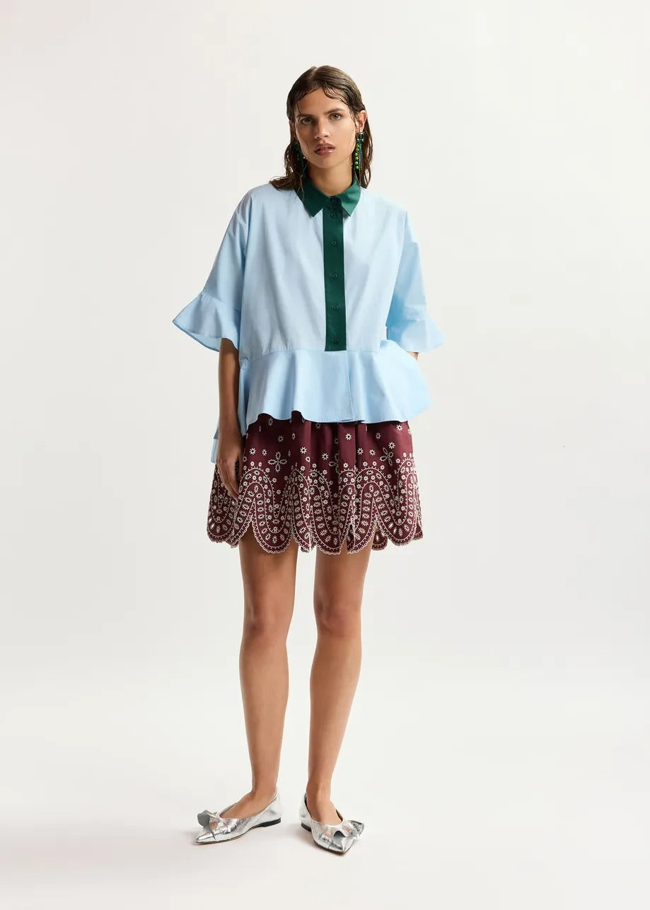 Light blue cotton peplum shirt with dark green contrast detailing
